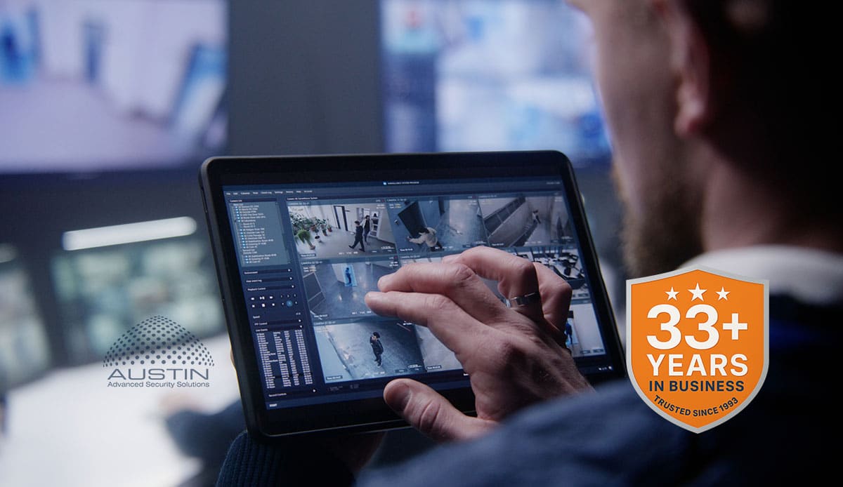 Person monitors security footage on tablet.