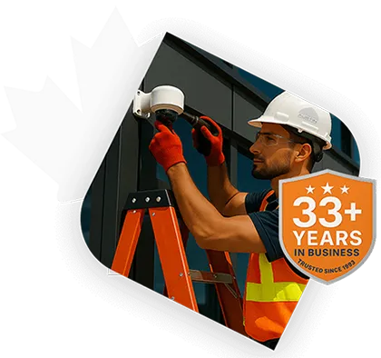 Technician installing security camera on building wall.